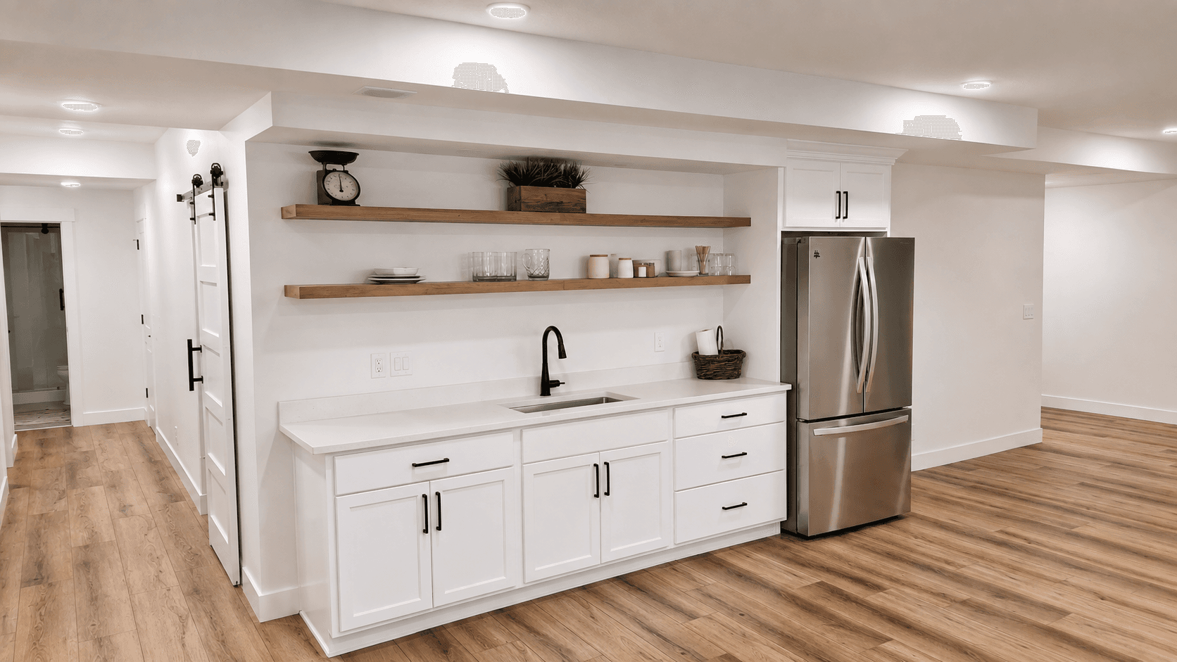 Basement wet bar and media area with custom cabinetry